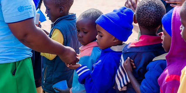 Child receiving medicine in line for deworming