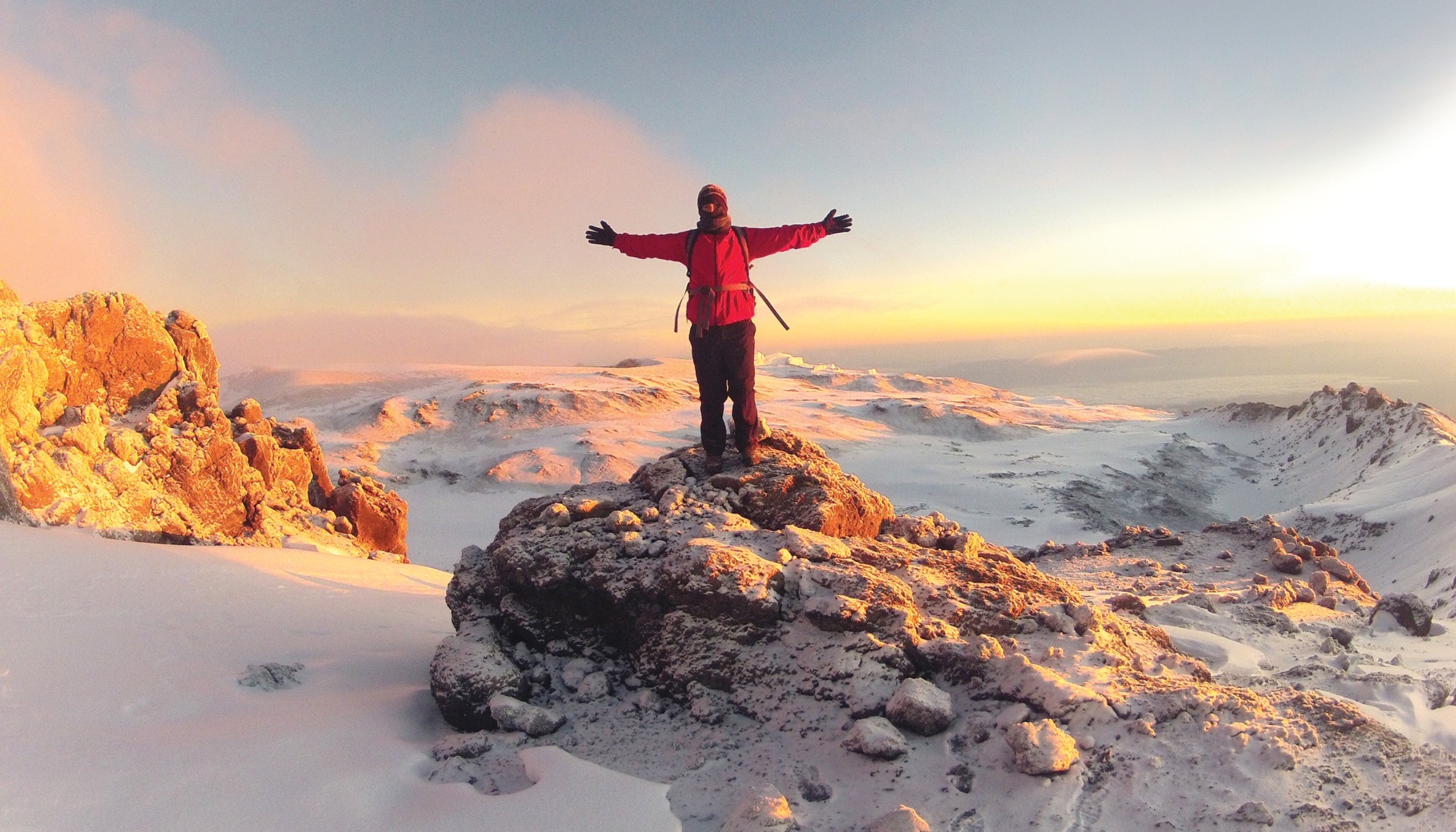 Hiker standing at the peak of Mt. Kilimanjaro.