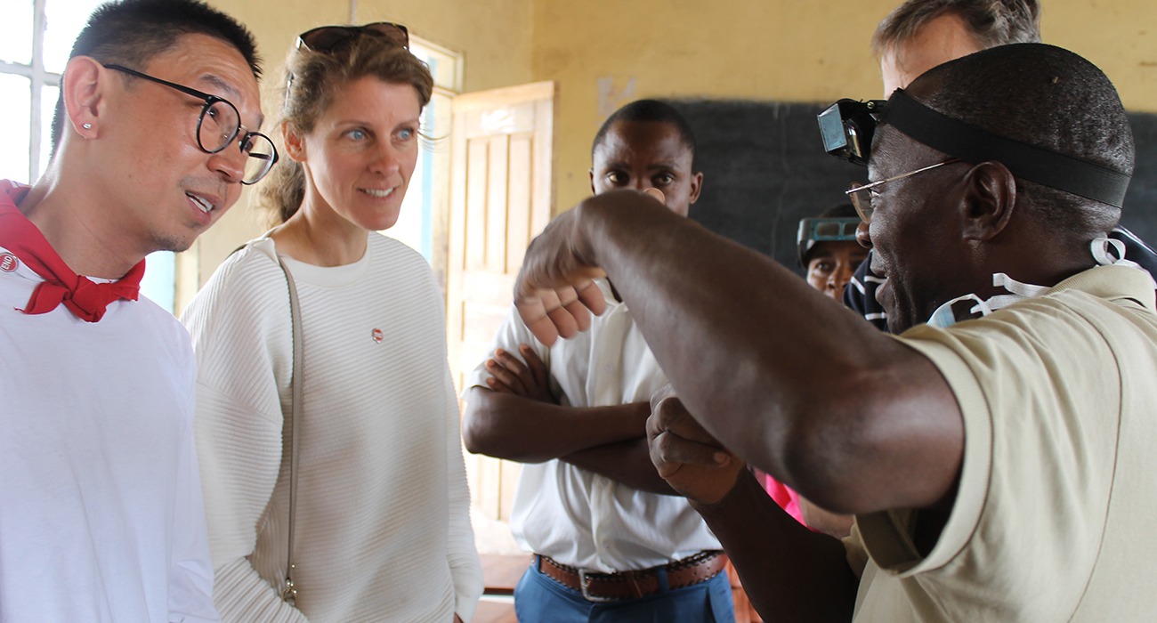 People listening to a man explain issues of trachoma.