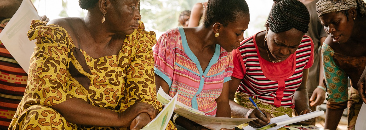 Three women filling out paperwork. A donation to help end neglected tropical diseases goes to people like them. 