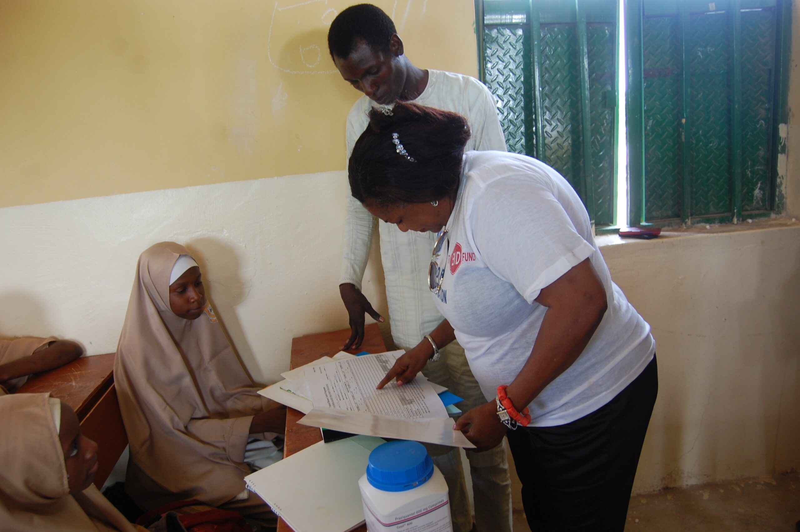 Rita checks the treatment register at a school.