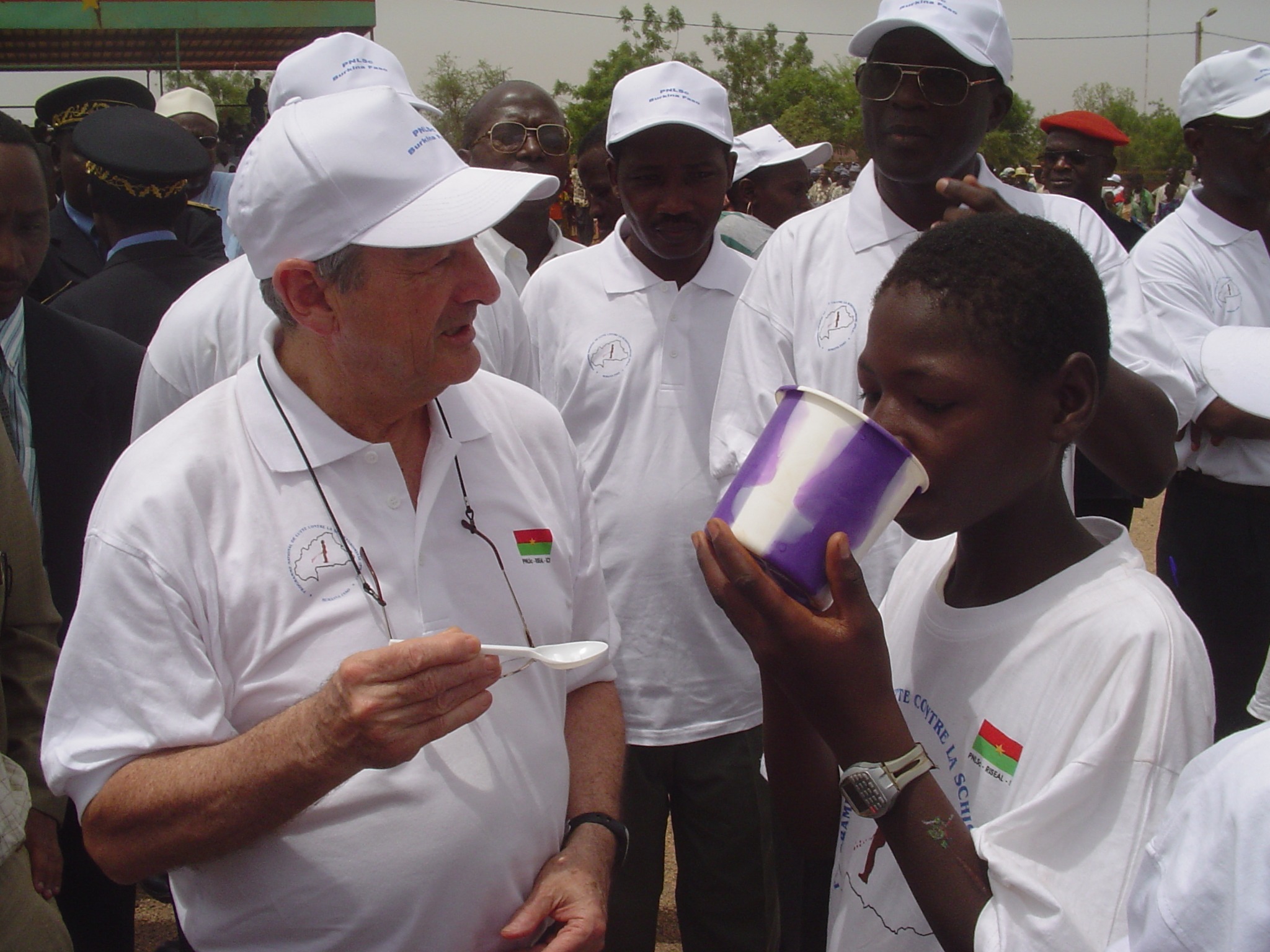 Child sipping water after taking praziquantel.