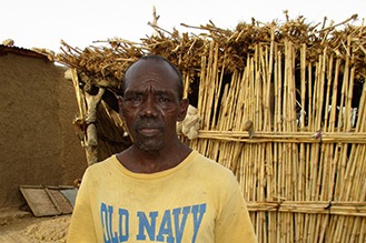 Man posing in front of his house.