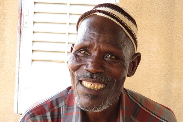 Man smiling in his house.