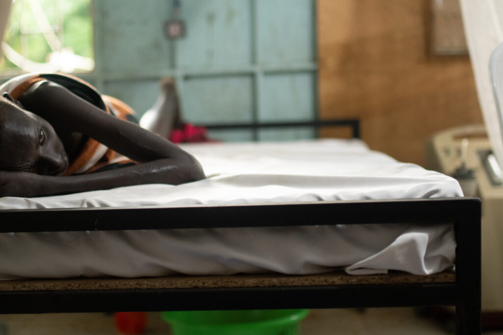 Berkede, 14, lays on his bed at the Jinka General Hospital in between receiving treatment for visceral leishmaniasis.