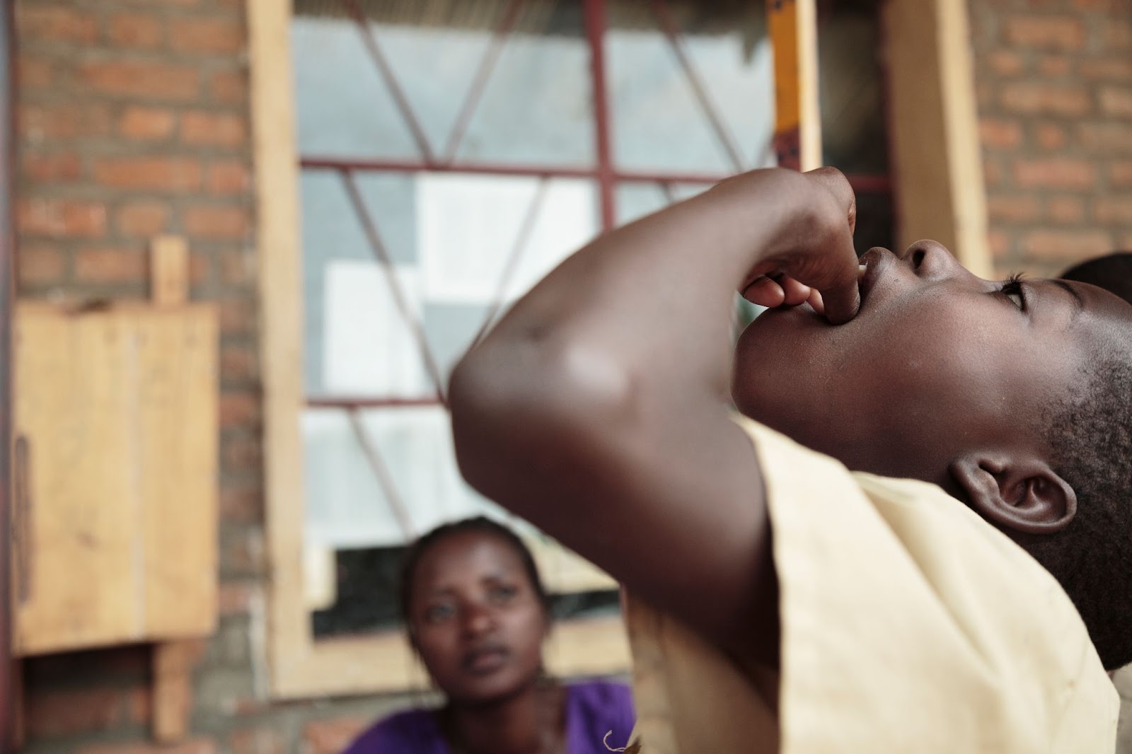Young student receives oral medication as part of comprehensive trachoma in Burundi prevention program at local school